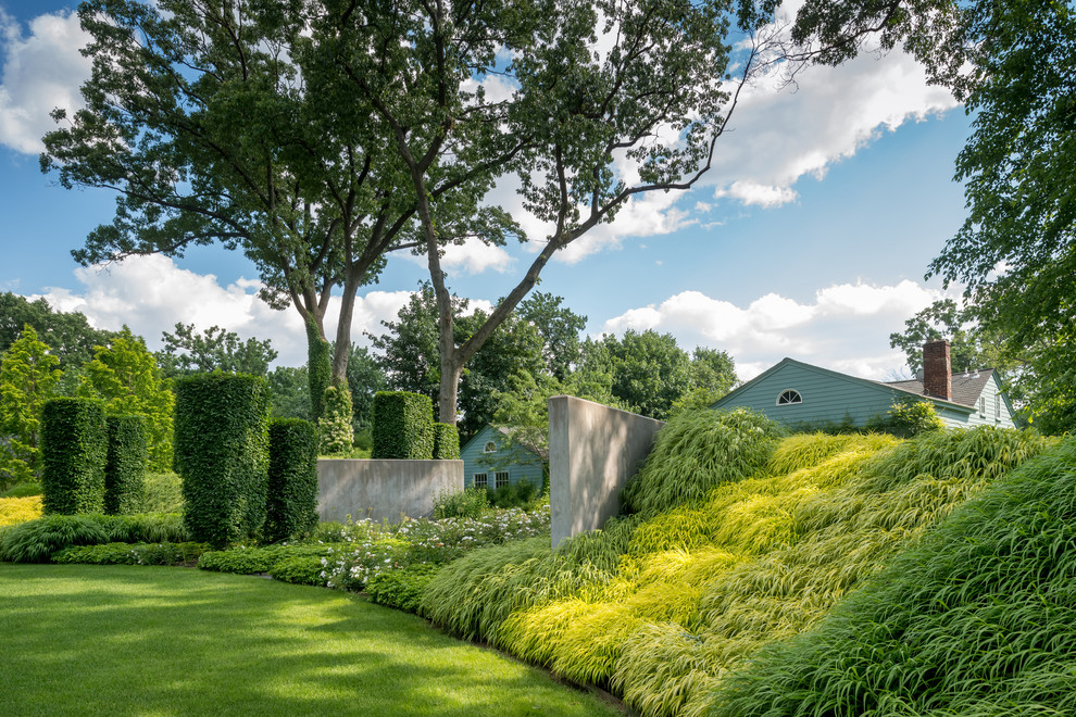 Ejemplo de jardín actual grande en primavera en patio trasero con jardín francés y exposición parcial al sol