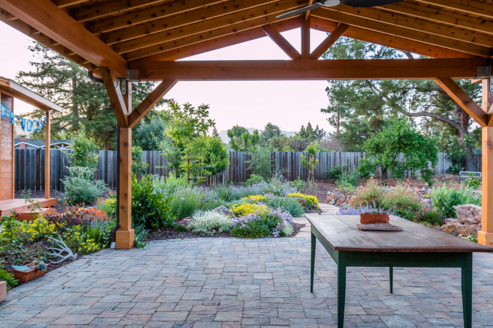 Imagen de jardín de secano mediterráneo de tamaño medio en primavera en patio trasero con exposición total al sol, fuente y adoquines de hormigón