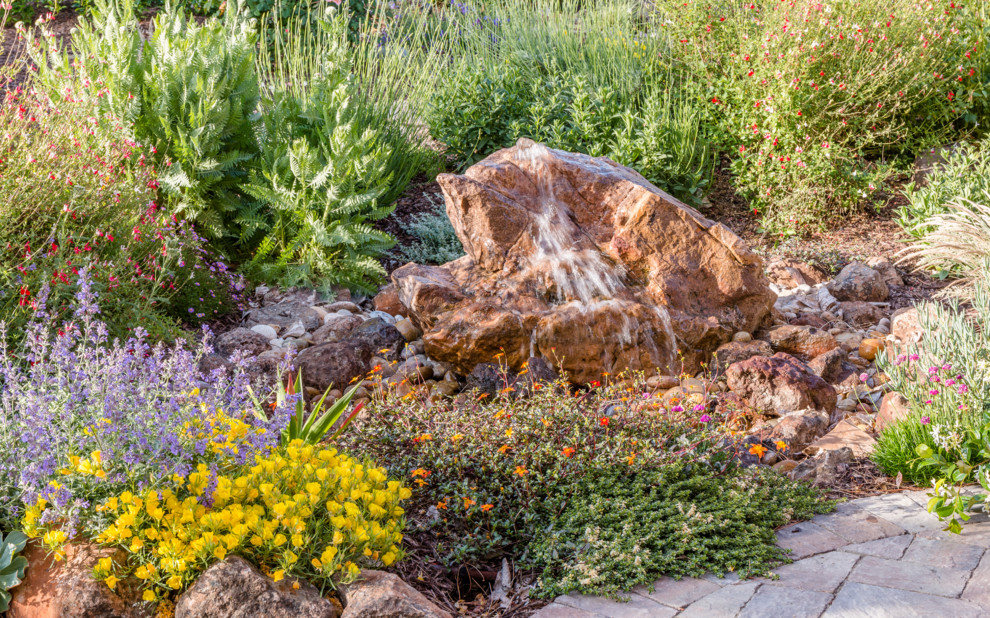 Mediterraner Garten hinter dem Haus mit Wasserspiel, direkter Sonneneinstrahlung und Betonboden in San Francisco