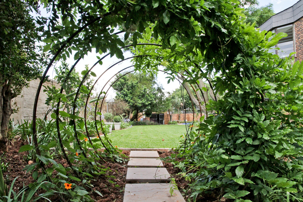 Imagen de camino de jardín ecléctico en patio lateral con adoquines de hormigón