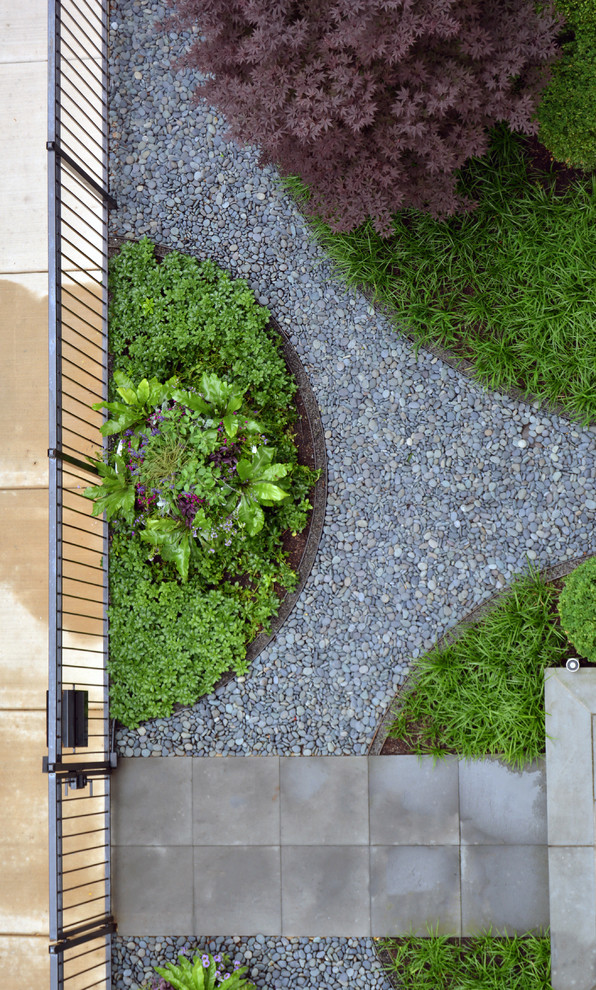Esempio di un giardino formale minimalista esposto a mezz'ombra di medie dimensioni e davanti casa con un ingresso o sentiero e pavimentazioni in pietra naturale