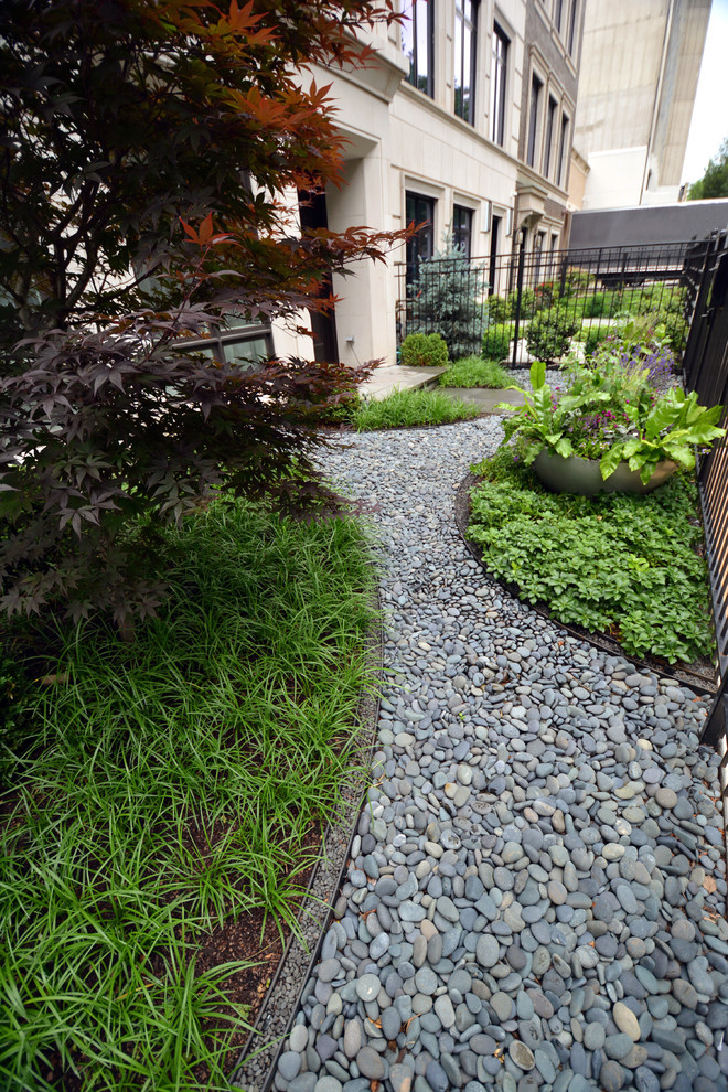 This is an example of a mid-sized modern partial sun front yard stone landscaping in Chicago.