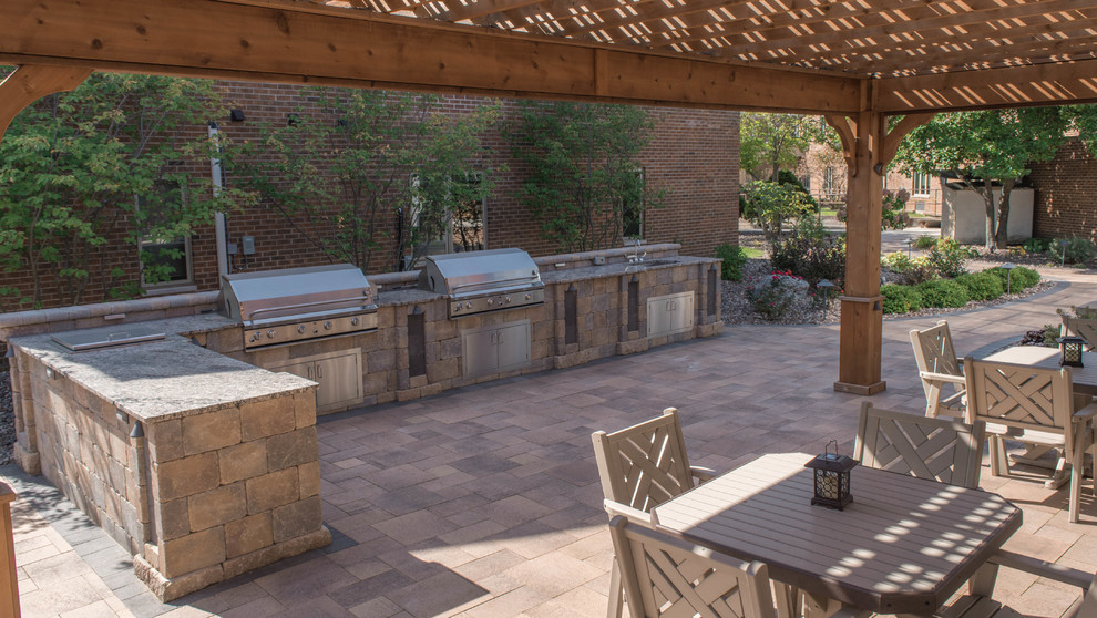Immagine di un grande patio o portico design in cortile con pavimentazioni in mattoni
