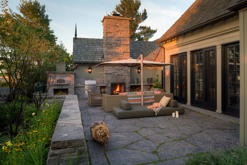 Cette image montre une terrasse craftsman avec une cour et des pavés en pierre naturelle.