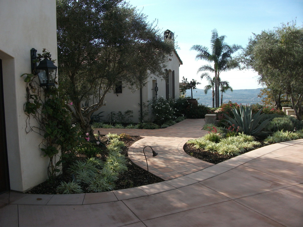 Foto de jardín mediterráneo de tamaño medio en patio lateral con fuente, exposición total al sol y adoquines de piedra natural