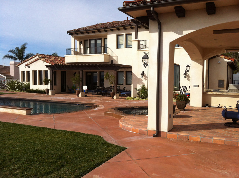 This is an example of a mid-sized mediterranean full sun backyard stone water fountain landscape in Orange County.