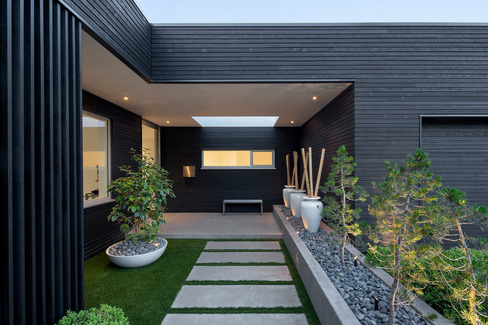 Immagine di un giardino minimalista esposto a mezz'ombra davanti casa con un ingresso o sentiero e pavimentazioni in cemento