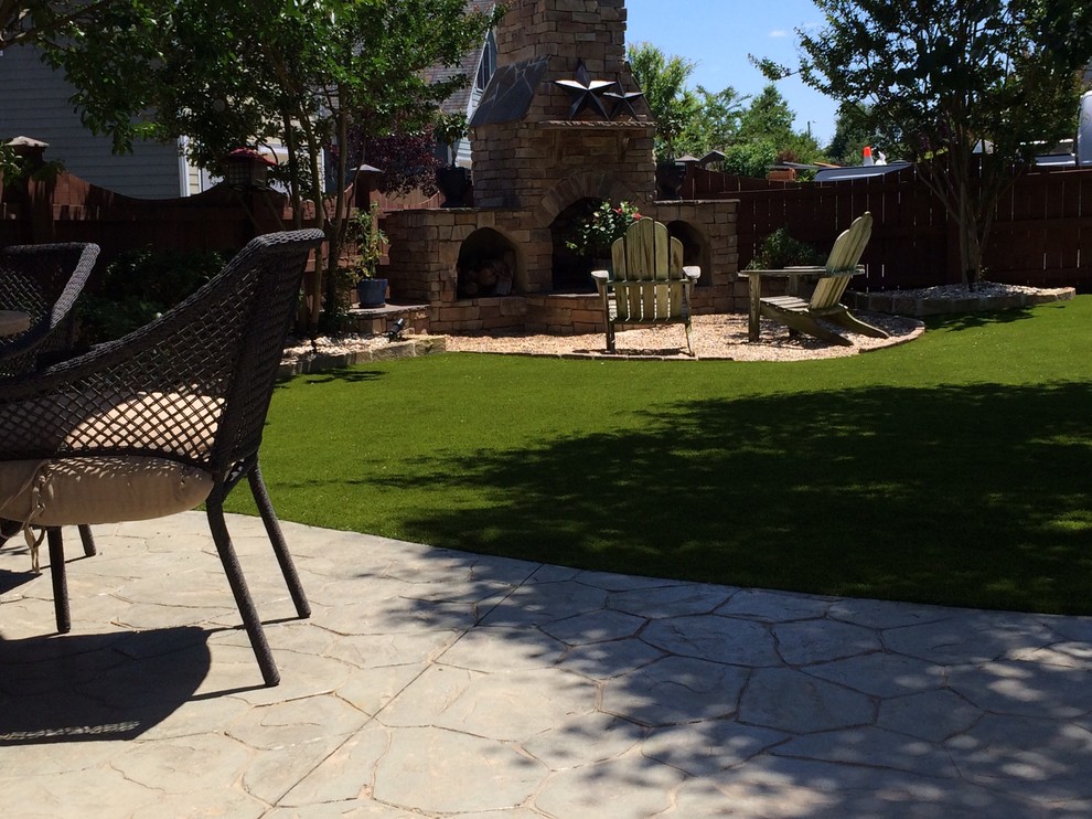 Immagine di un grande giardino minimal esposto a mezz'ombra dietro casa con un caminetto e ghiaia