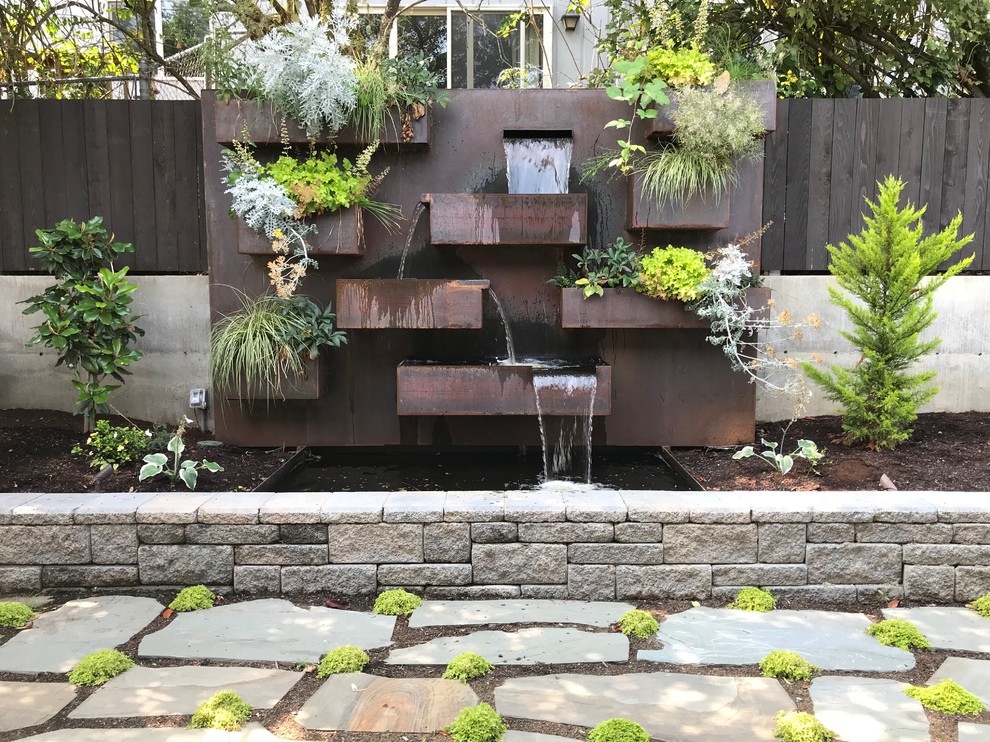Esempio di un laghetto da giardino stile americano dietro casa con pavimentazioni in pietra naturale