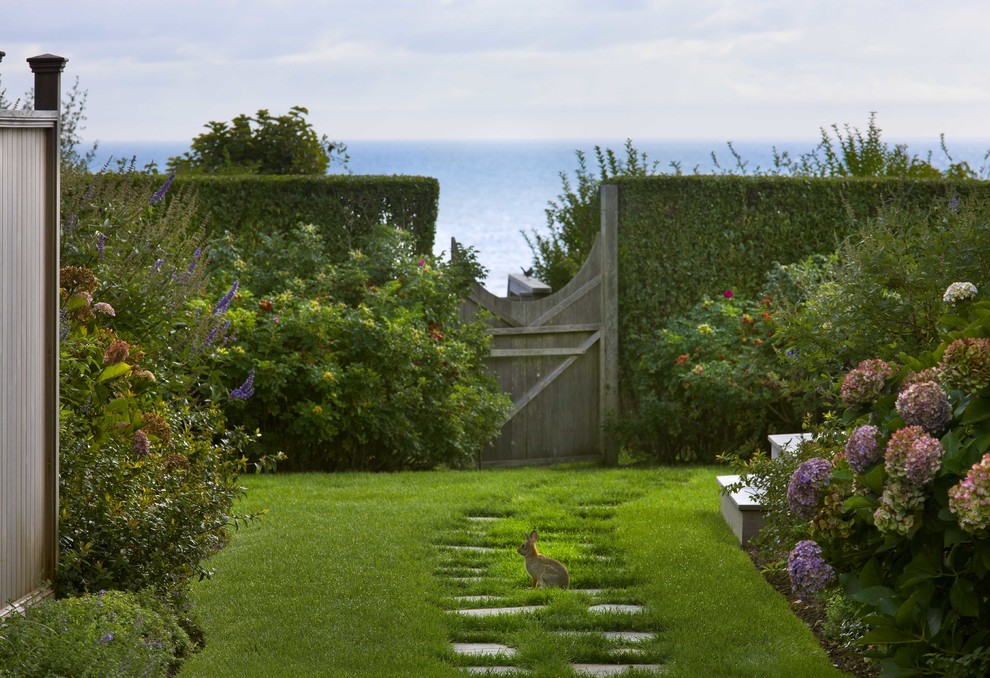 Идея дизайна: солнечный регулярный сад на заднем дворе в морском стиле с садовой дорожкой или калиткой, хорошей освещенностью и покрытием из каменной брусчатки