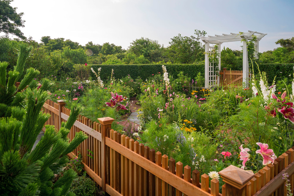 Idee per un giardino formale costiero esposto in pieno sole dietro casa e di medie dimensioni in primavera con pavimentazioni in mattoni e recinzione in legno