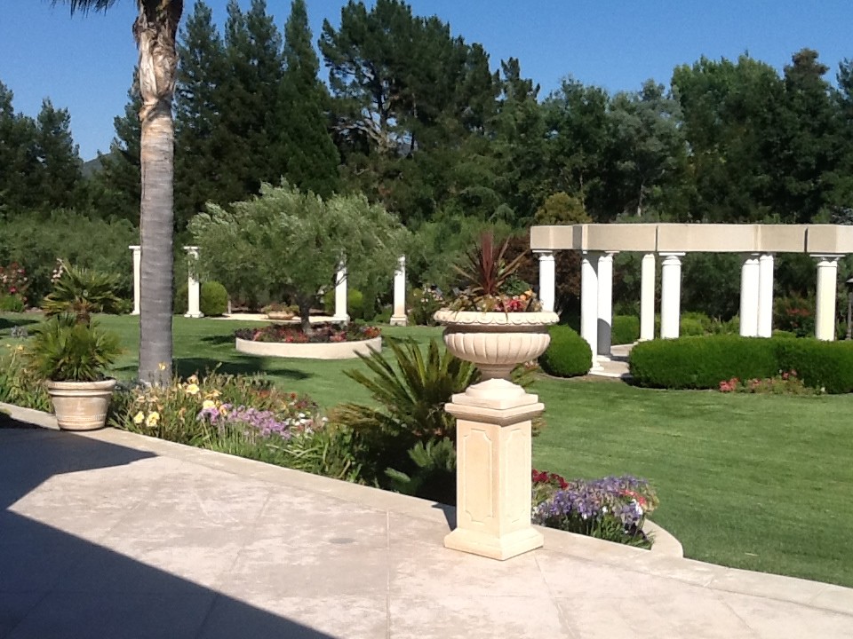 Cette photo montre un très grand jardin arrière méditerranéen avec une exposition partiellement ombragée et des pavés en béton.