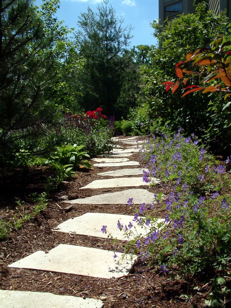 Aménagement d'un grand aménagement d'entrée ou allée de jardin latéral classique avec des pavés en pierre naturelle.