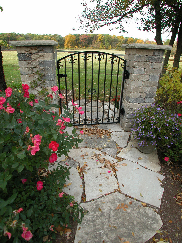 Cette photo montre un aménagement d'entrée ou allée de jardin latéral chic avec des pavés en pierre naturelle.