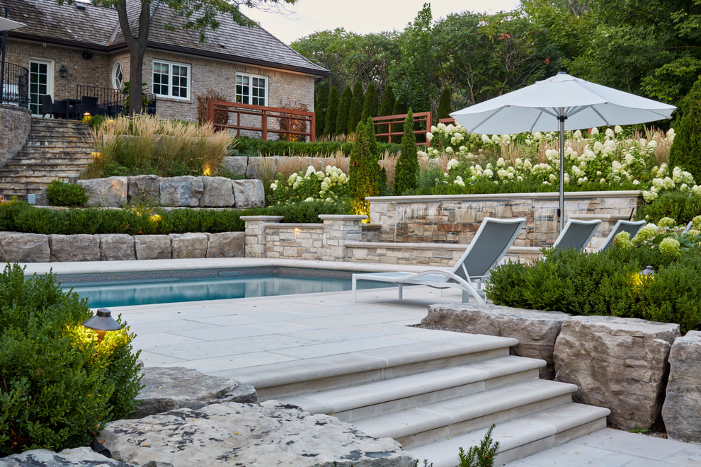 Imagen de jardín clásico extra grande en verano en patio trasero con adoquines de piedra natural, jardín francés y exposición parcial al sol