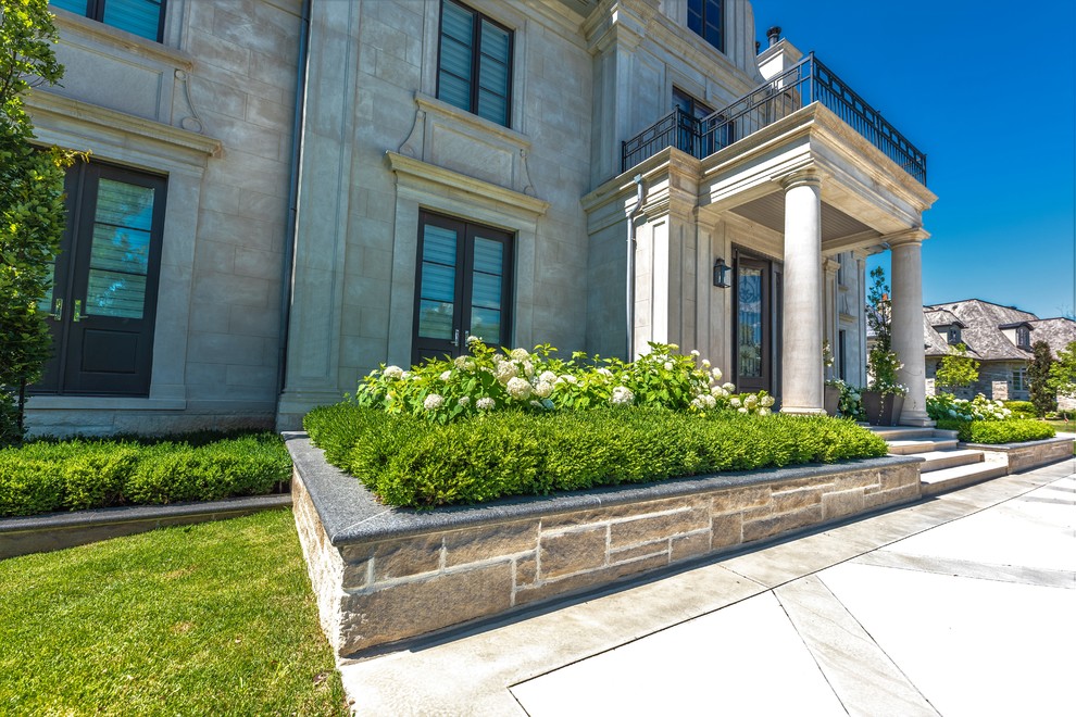 Esempio di un ampio vialetto d'ingresso classico esposto in pieno sole davanti casa in estate con un giardino in vaso e pavimentazioni in cemento