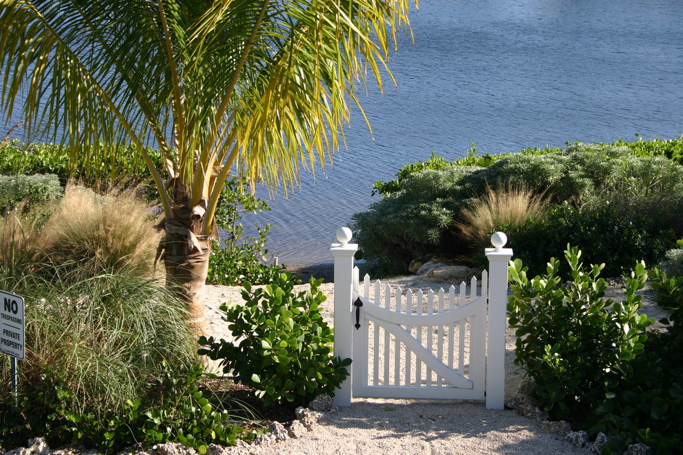 На фото: большой летний засухоустойчивый сад на переднем дворе в морском стиле с полуденной тенью, покрытием из гравия и садовой дорожкой или калиткой с