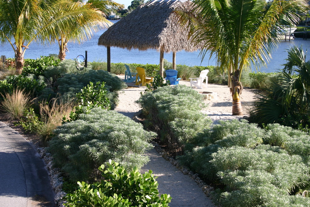Imagen de camino de jardín de secano costero grande en verano en patio delantero con exposición parcial al sol y gravilla