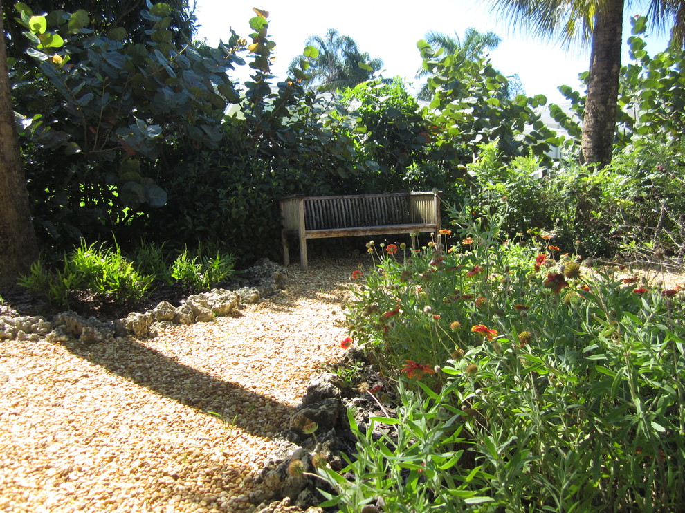Design ideas for a medium sized world-inspired back xeriscape partial sun garden for summer in Miami with a garden path and gravel.