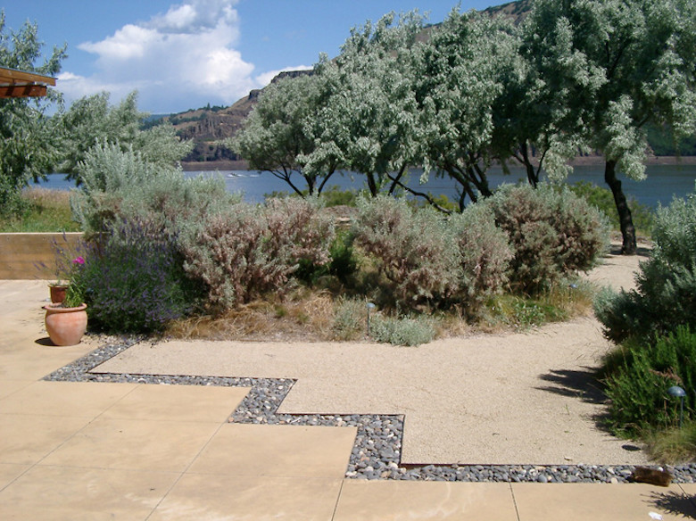 Diseño de jardín actual grande en patio trasero con fuente, exposición parcial al sol y adoquines de piedra natural