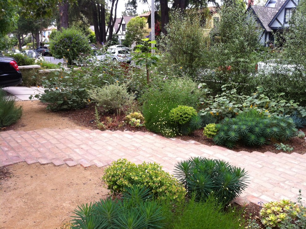 Foto de jardín mediterráneo en patio delantero con adoquines de ladrillo