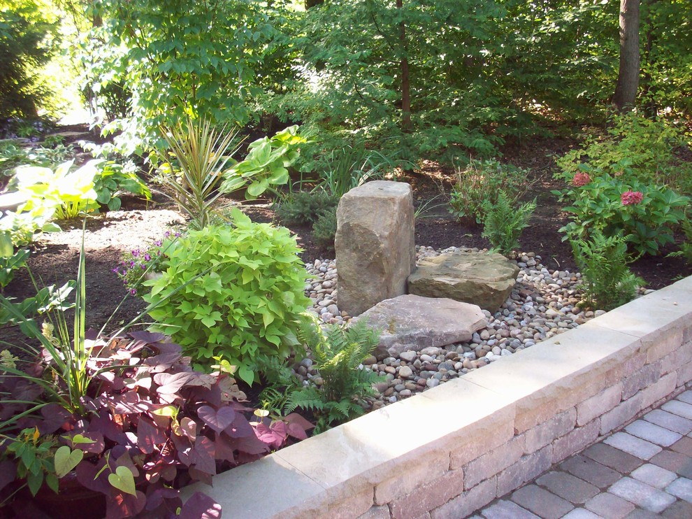 Esempio di un giardino stile americano esposto a mezz'ombra di medie dimensioni e dietro casa con pavimentazioni in pietra naturale