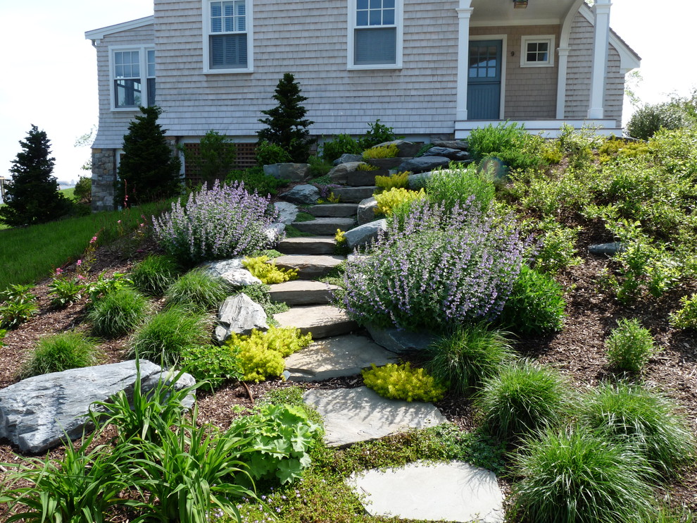 Ispirazione per un giardino formale tradizionale esposto in pieno sole di medie dimensioni e dietro casa con un ingresso o sentiero e pacciame