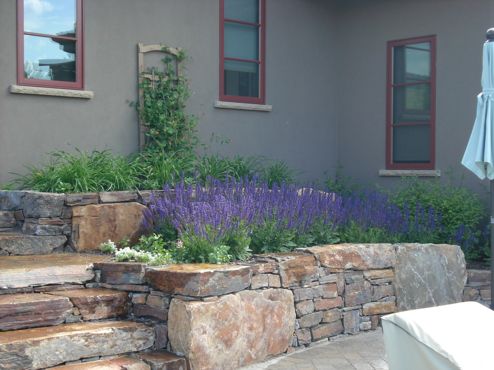Idee per un piccolo giardino formale tradizionale esposto in pieno sole dietro casa in primavera con un focolare e pavimentazioni in pietra naturale