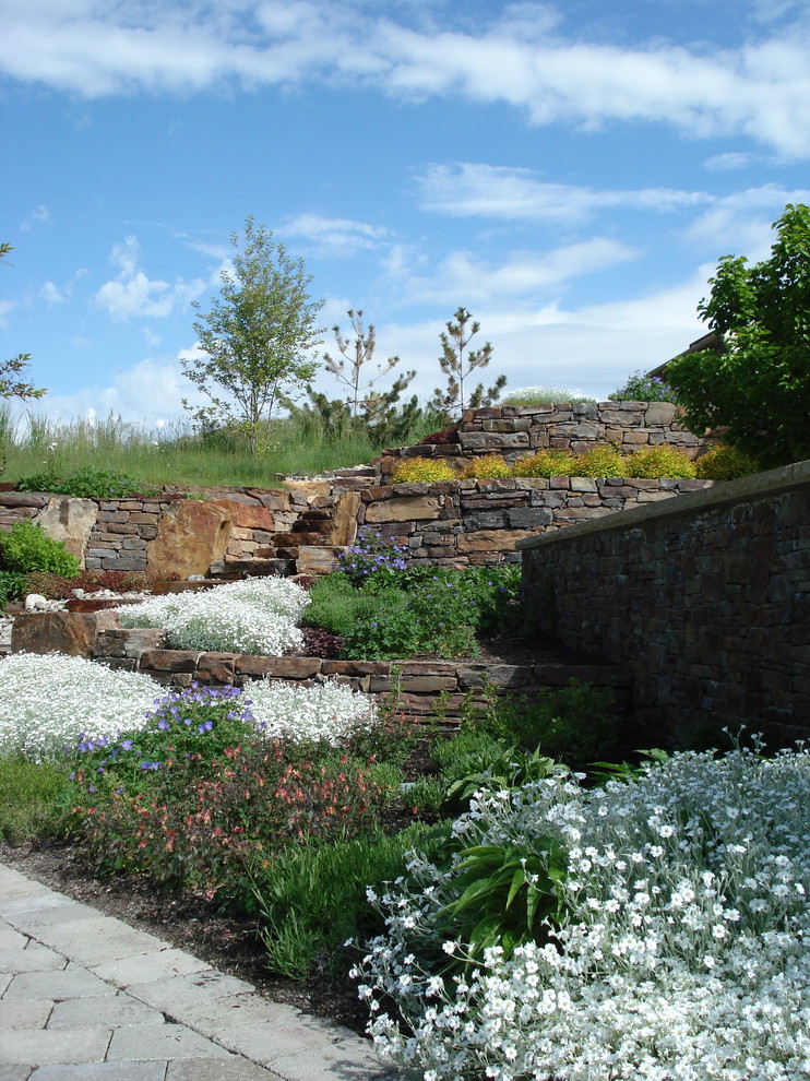 Diseño de jardín tradicional pequeño en primavera en patio trasero con jardín francés, brasero, exposición total al sol y adoquines de piedra natural