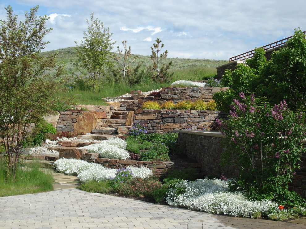 Aménagement d'un petit jardin à la française arrière classique au printemps avec un foyer extérieur, une exposition ensoleillée et des pavés en pierre naturelle.