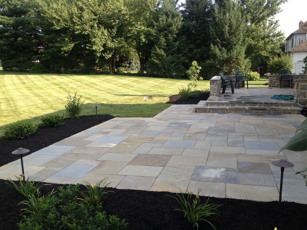 Photo of a large contemporary full sun backyard stone landscaping in Philadelphia.