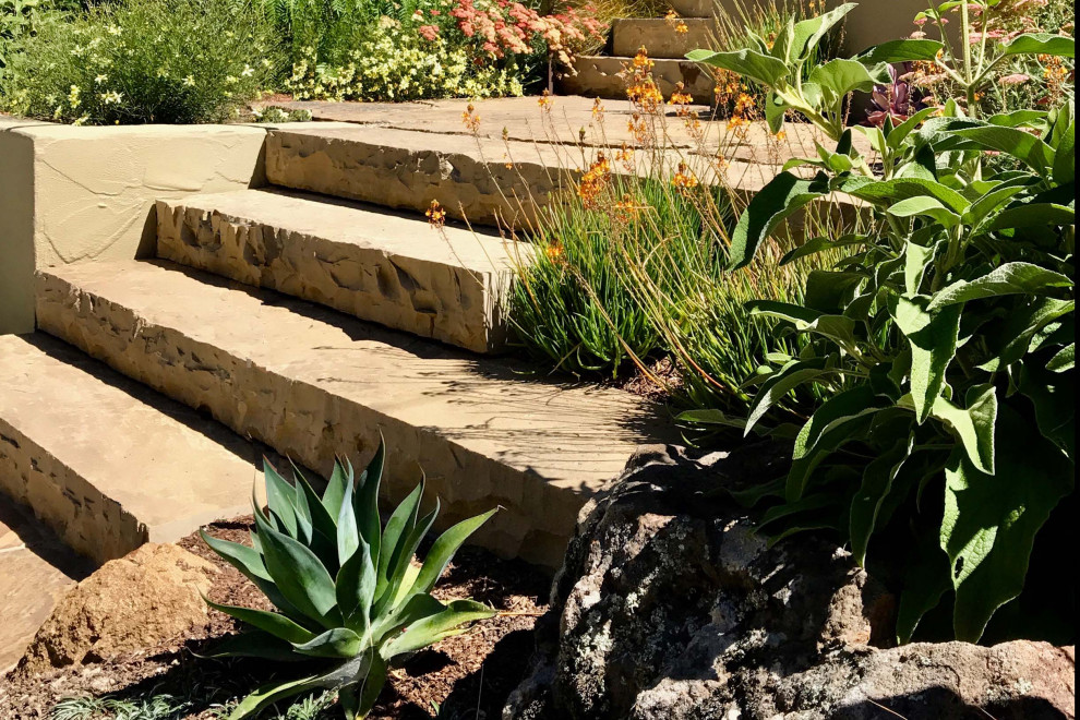Пример оригинального дизайна: солнечный засухоустойчивый сад на переднем дворе в средиземноморском стиле с дорожками, хорошей освещенностью и покрытием из каменной брусчатки