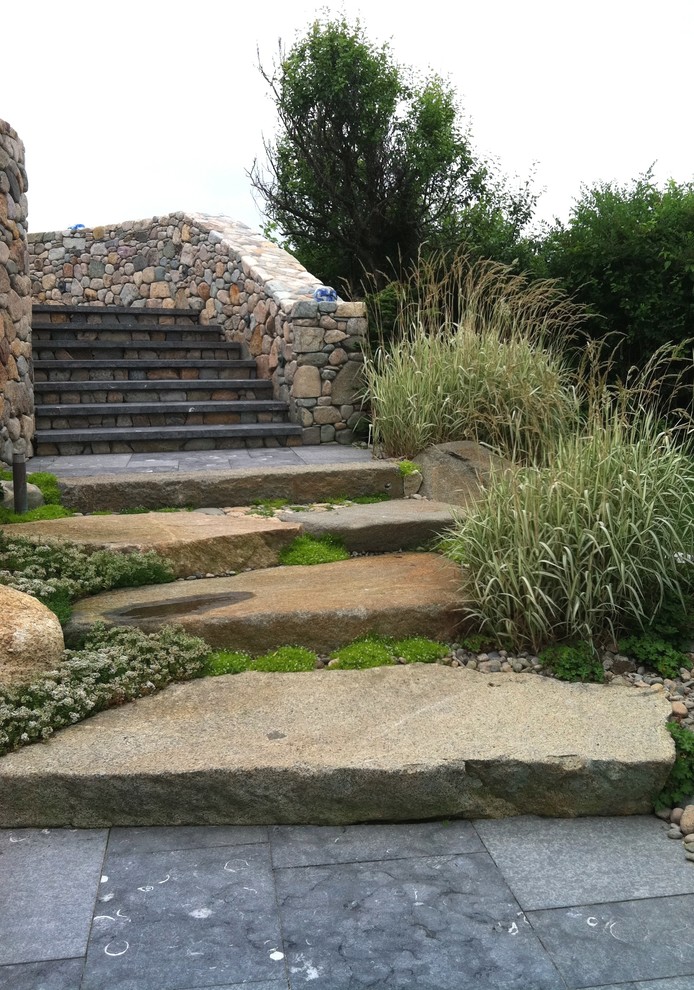 Imagen de camino de jardín tradicional de tamaño medio en primavera en patio delantero con jardín francés, exposición total al sol y adoquines de piedra natural