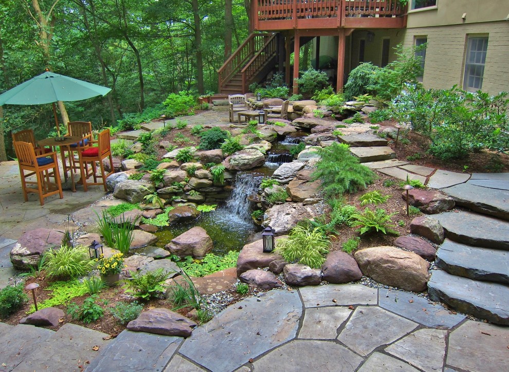 Esempio di un giardino formale eclettico di medie dimensioni con un pendio, una collina o una riva e pavimentazioni in pietra naturale