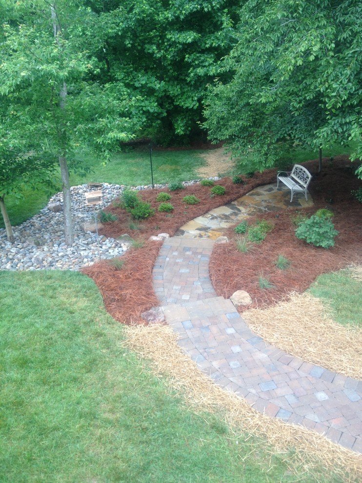 This is an example of a mid-sized transitional shade backyard stone garden path in Other.