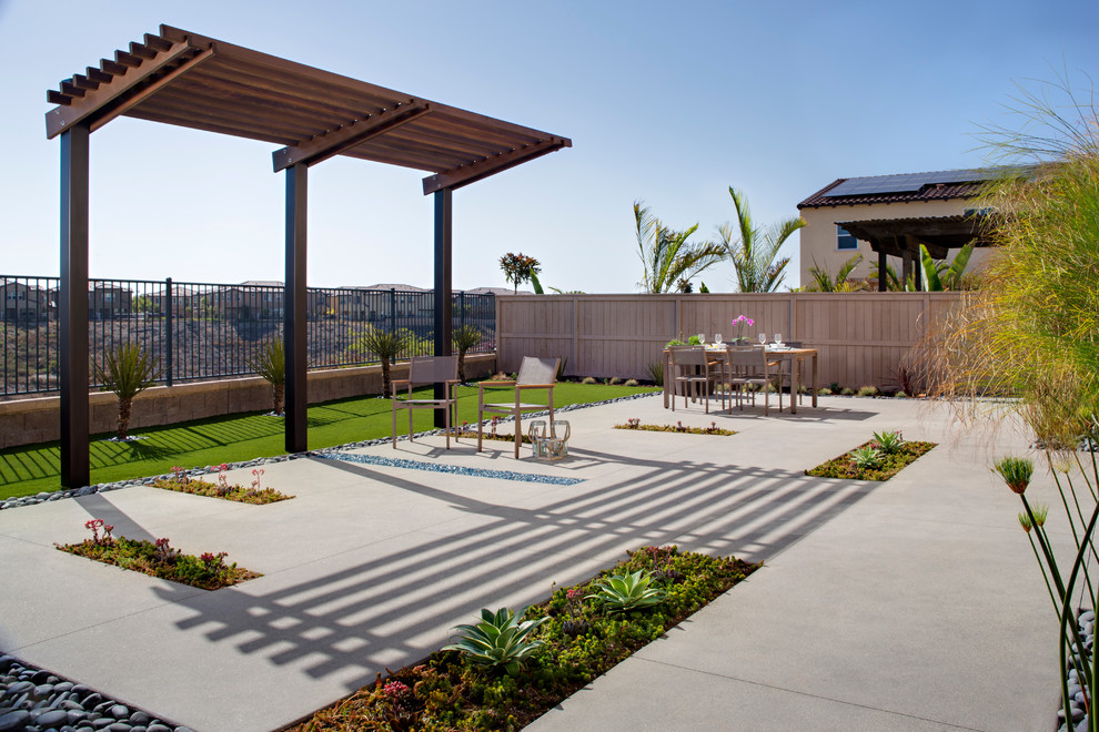 Inspiration for a mid-sized contemporary full sun backyard concrete paver landscaping in San Diego with a fire pit for summer.