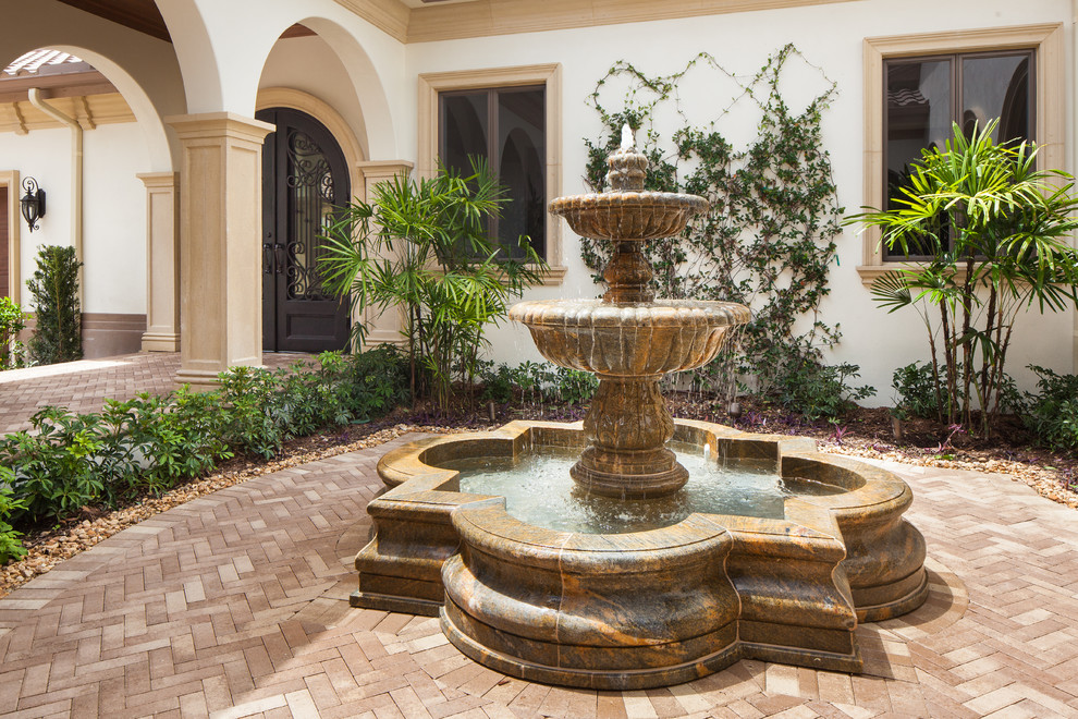 Geometrischer, Mittelgroßer, Halbschattiger Mediterraner Garten im Innenhof mit Wasserspiel und Natursteinplatten in Miami