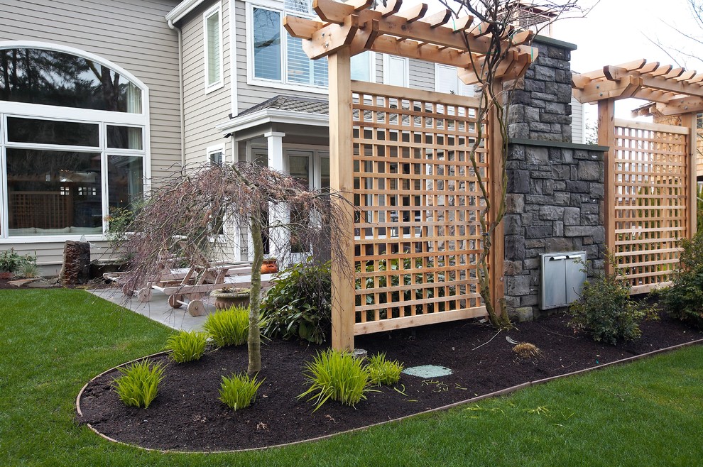 This is an example of a mid-sized contemporary partial sun backyard stone landscaping in Seattle with a fire pit for winter.