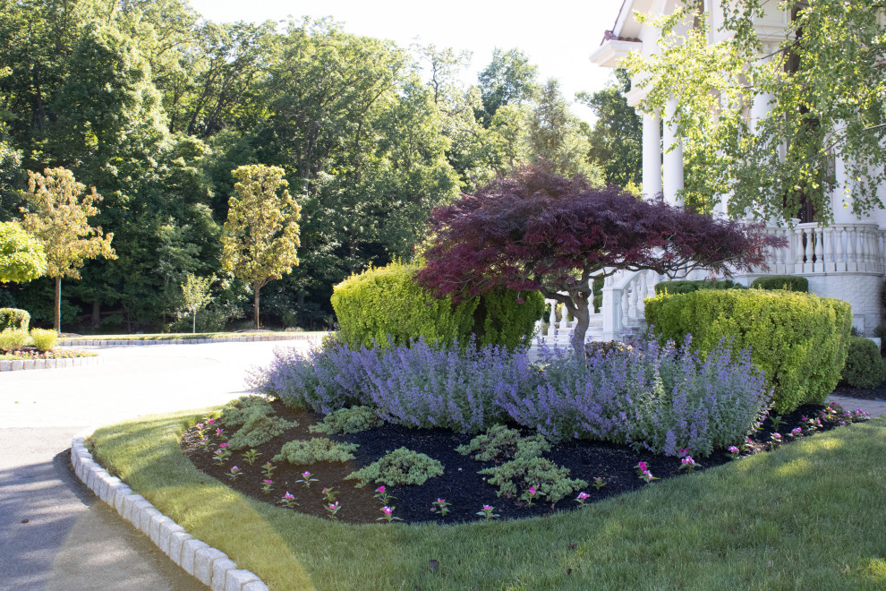 This is an example of a mid-sized contemporary full sun side yard concrete paver landscaping in New York for summer.