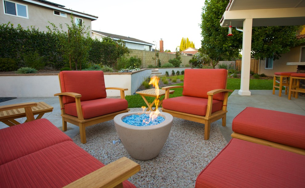 Großer Moderner Garten hinter dem Haus, im Sommer mit Feuerstelle, Betonboden und direkter Sonneneinstrahlung in Orange County