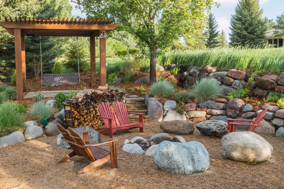 Photo of a large back full sun garden for summer in Denver with a fire feature and gravel.