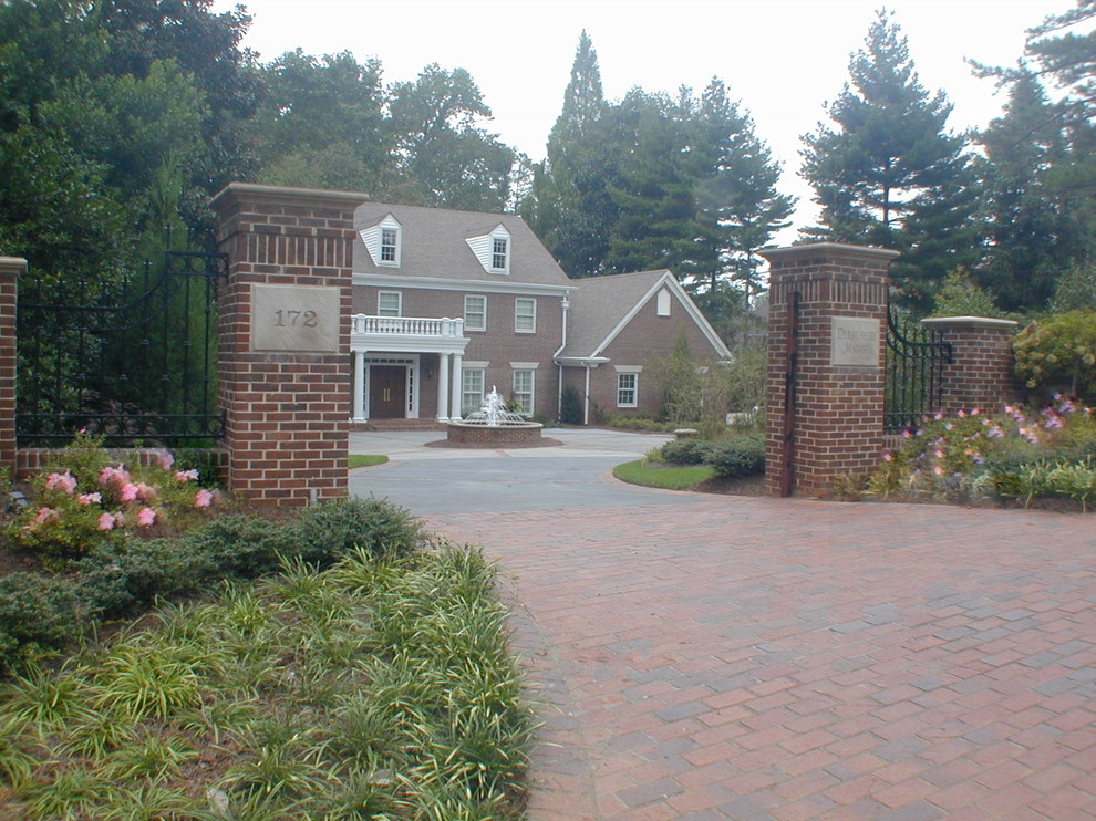 This is an example of a large classic front driveway full sun garden in Atlanta with a water feature and brick paving.