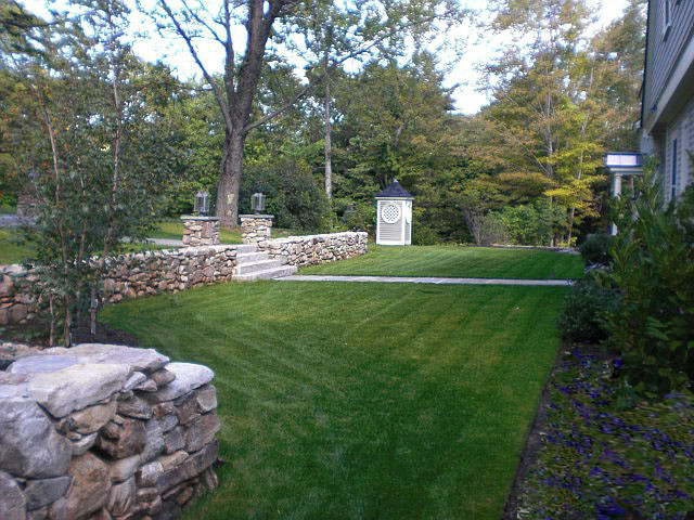 Ispirazione per un giardino country esposto a mezz'ombra davanti casa in inverno con un muro di contenimento e pavimentazioni in pietra naturale