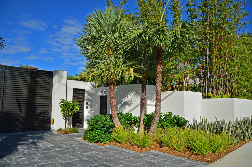 Großer Asiatischer Vorgarten mit Auffahrt, direkter Sonneneinstrahlung und Natursteinplatten in Miami