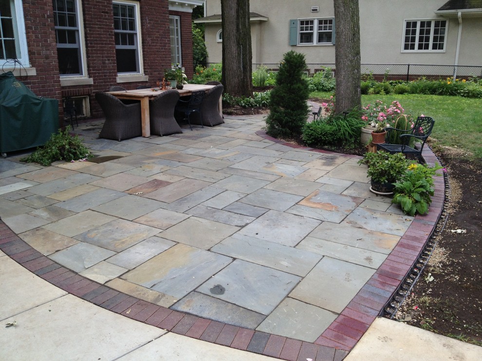 Large classic back garden in Minneapolis with natural stone paving.