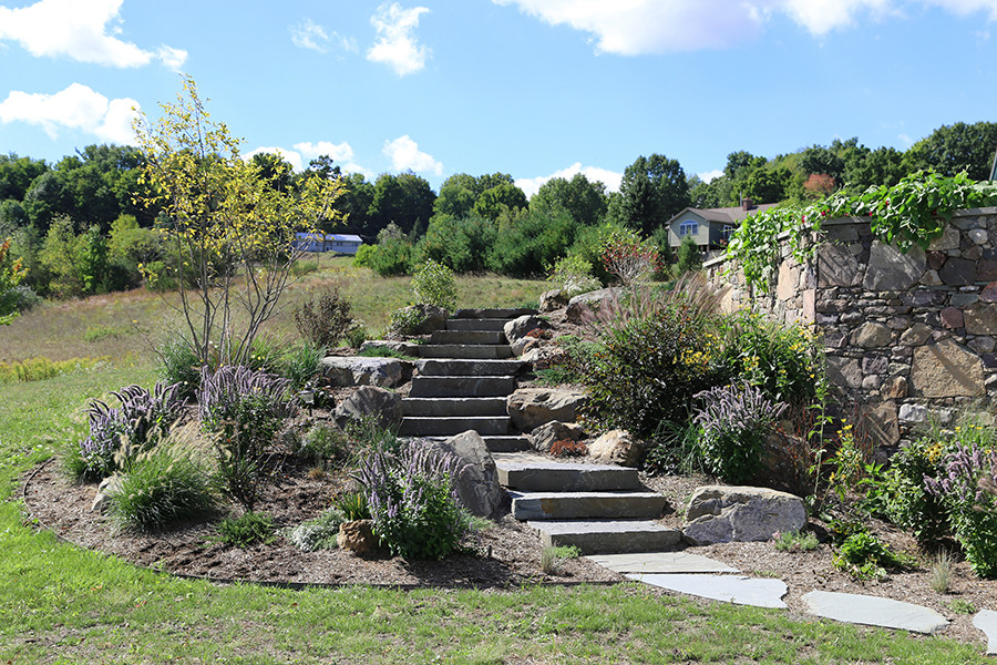 Foto di un ampio giardino country dietro casa con sassi e rocce e pavimentazioni in pietra naturale