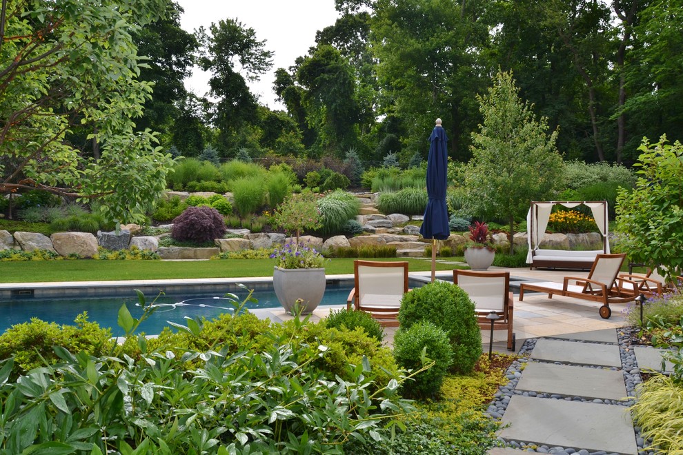 This is an example of a large contemporary partial sun backyard concrete paver garden path in New York for summer.