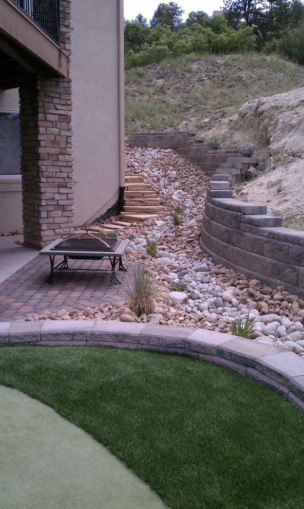 Small traditional back full sun garden in Denver with a fire feature and concrete paving.