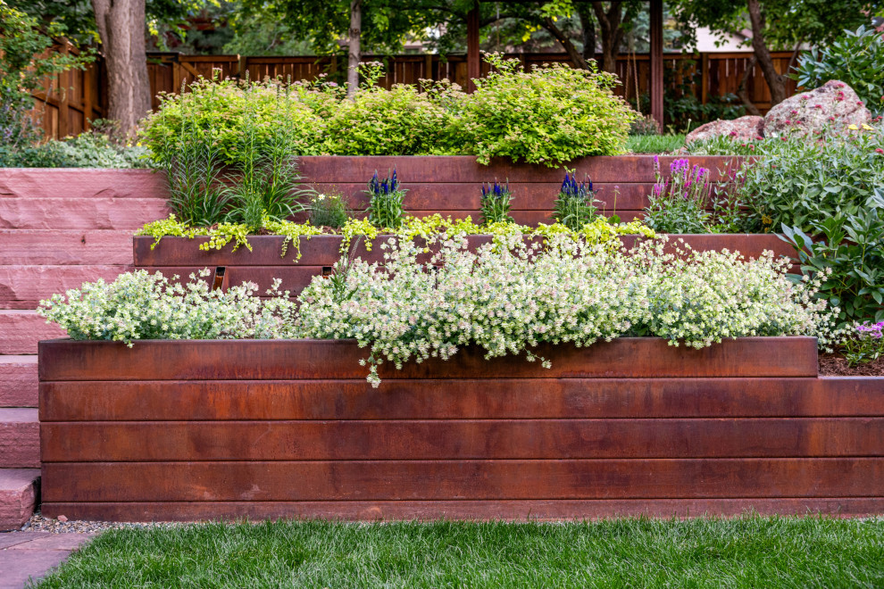 Inspiration for a small craftsman partial sun backyard stone retaining wall landscape in Denver.