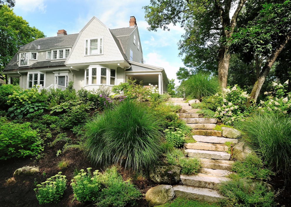 Esempio di un grande giardino formale design in ombra in estate con un pendio, una collina o una riva, pavimentazioni in pietra naturale e scale